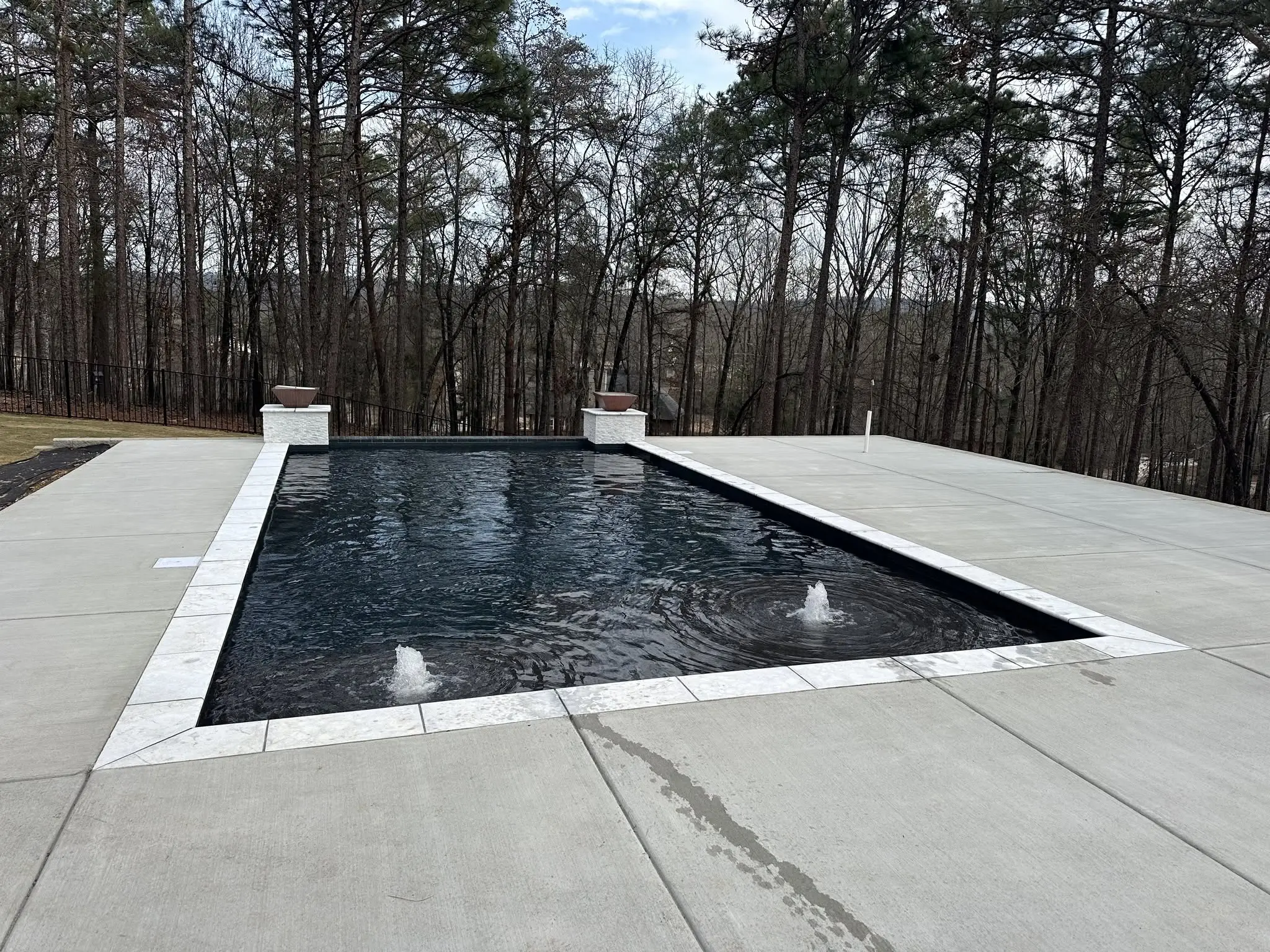 Gunite pool with onyx plaster and a raised wall with fire bowls in Birmingham