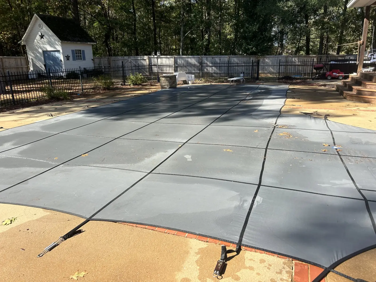 Pool closed for winter under a safety cover