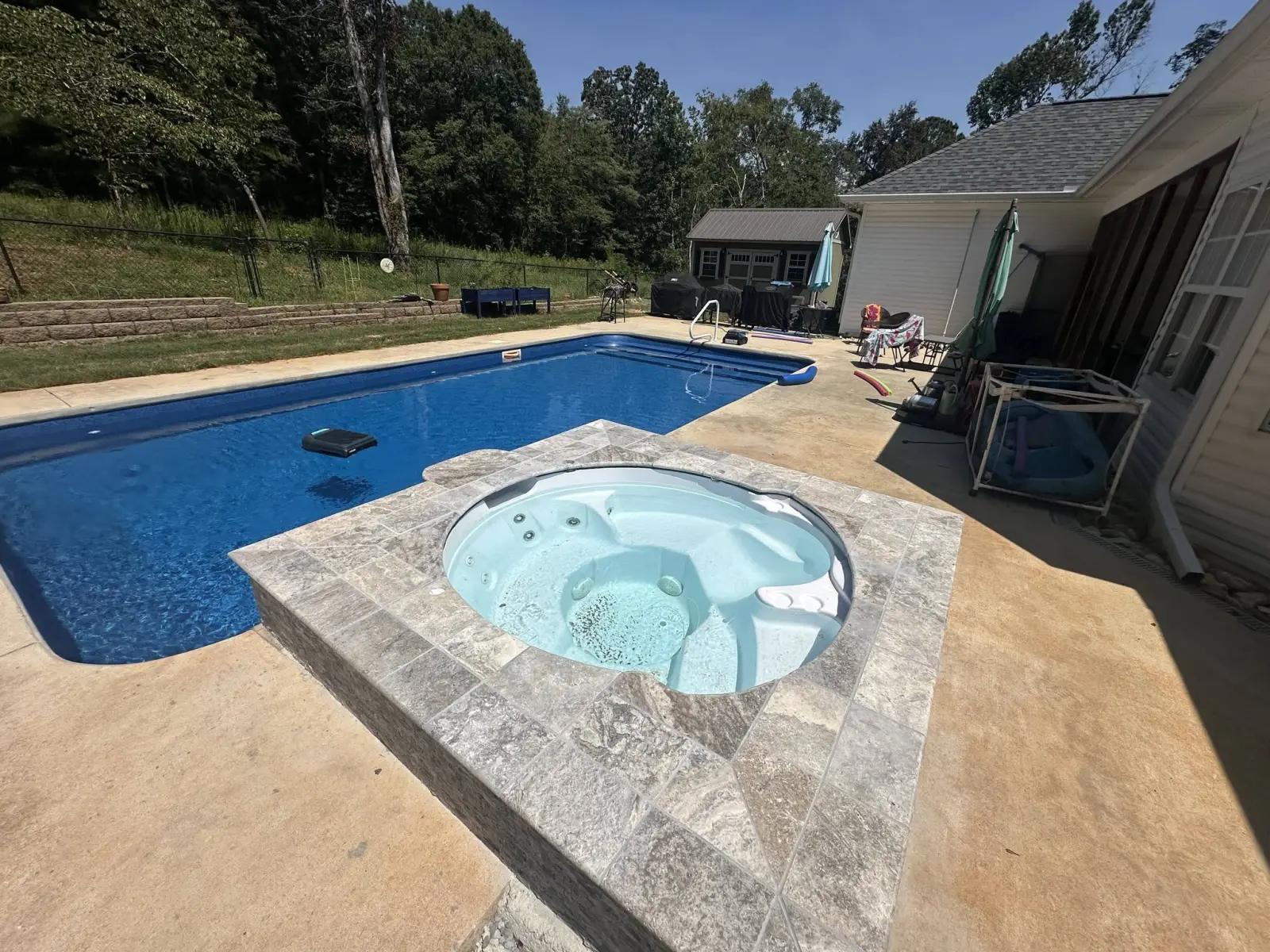 Vinyl liner pool with a raised travertine spa